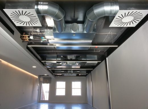 Exposed ducted air conditioning installation Interior view of a modern space with exposed ductwork and ventilation fans on the ceiling