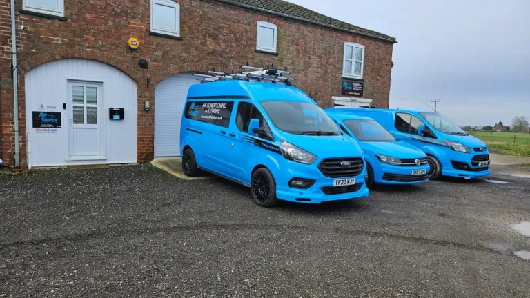 Air-Switch Offices in Moorby Three blue Air-Switch vans parked outside a brick building with white windows and doors.