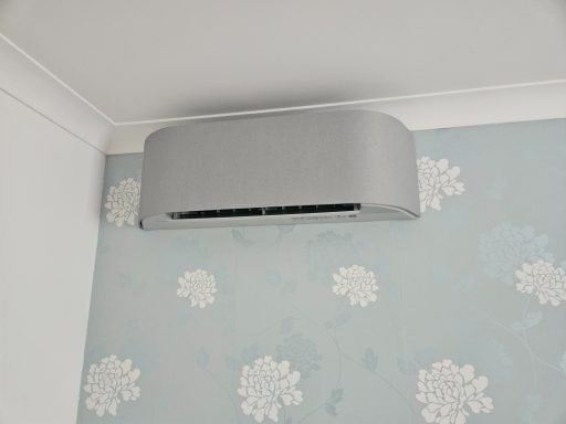 Toshiba Haori in light grey Light grey Toshiba Haroi air conditioning unit mounted on a light blue wall with floral patterns.