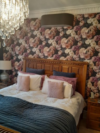 Toshiba Haori Installation in dark grey A classy and cosy bedroom with a floral wallpaper and chandelier style light with Toshiba Haori in dark grey above wooden head board