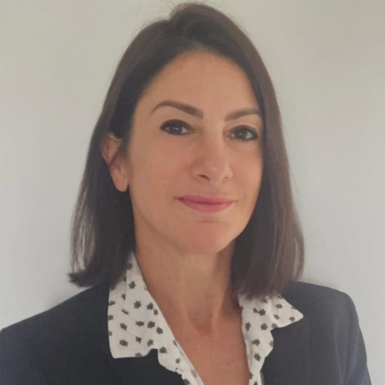 Fran N-S. A professional-looking woman with shoulder-length dark hair and a neat blazer, smiling.