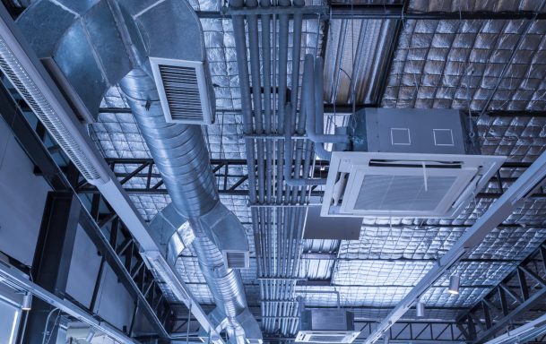 Exposed air conditioning and ventilation installation industial look airconditioning and ventilation installation. Picure in blue tones emphasising the metalic look of the exposed ductwork