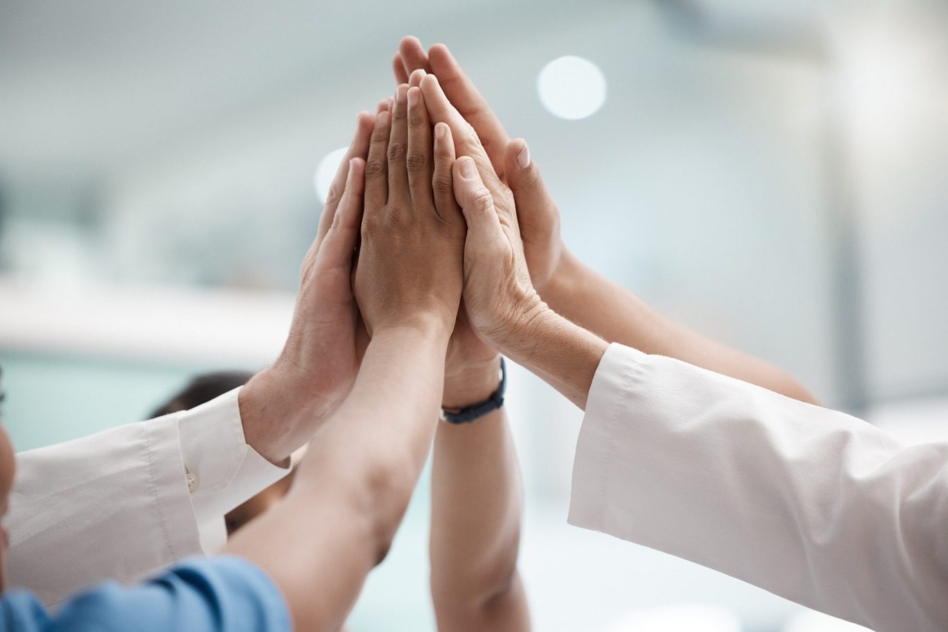 Opprtunities to join our team Several hands of diverse individuals stacked together in a gesture of teamwork.
