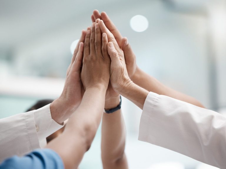 Our hardworking team would be pleased to assist with your enquiry Several hands coming together in a gesture of teamwork or celebration.